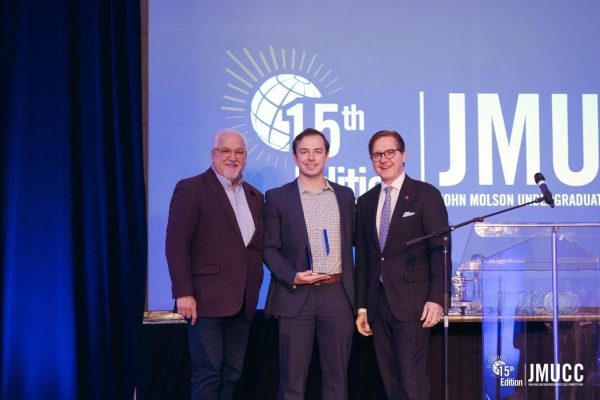 Student holding trophy in between two mentors