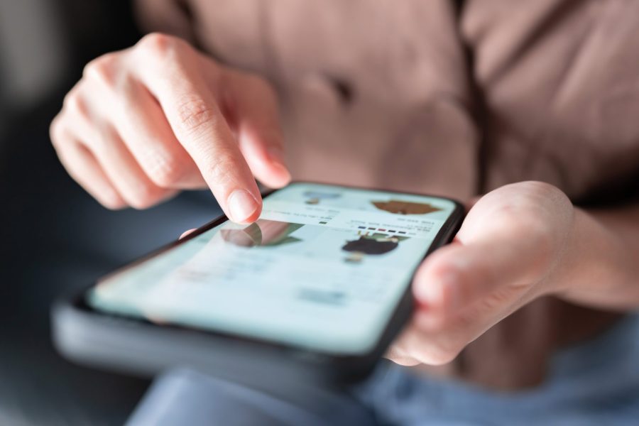 Woman online shopping for fashion clothes on a smart phone