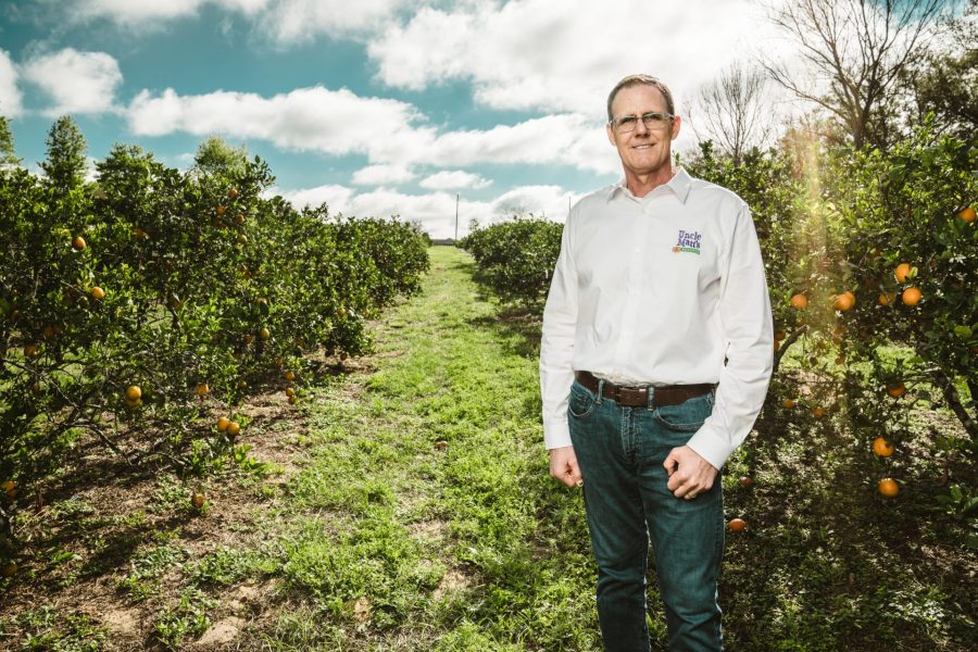 Matt McLean standing in an orange grove.