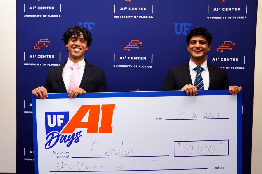Two students hold a $10,000 prize check.