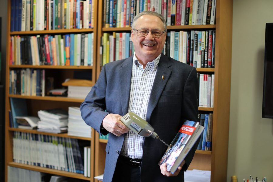 Richard Lutz holds a drill and a textbook.