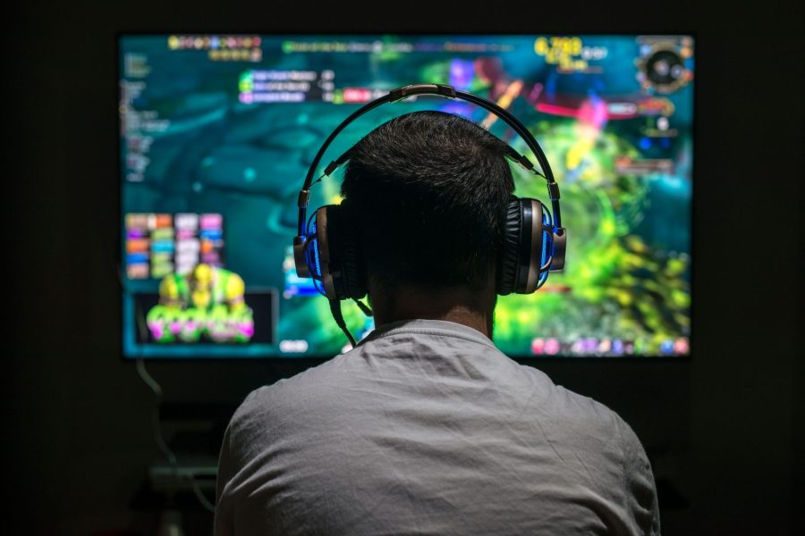 Young gamer playing video game wearing headphone.