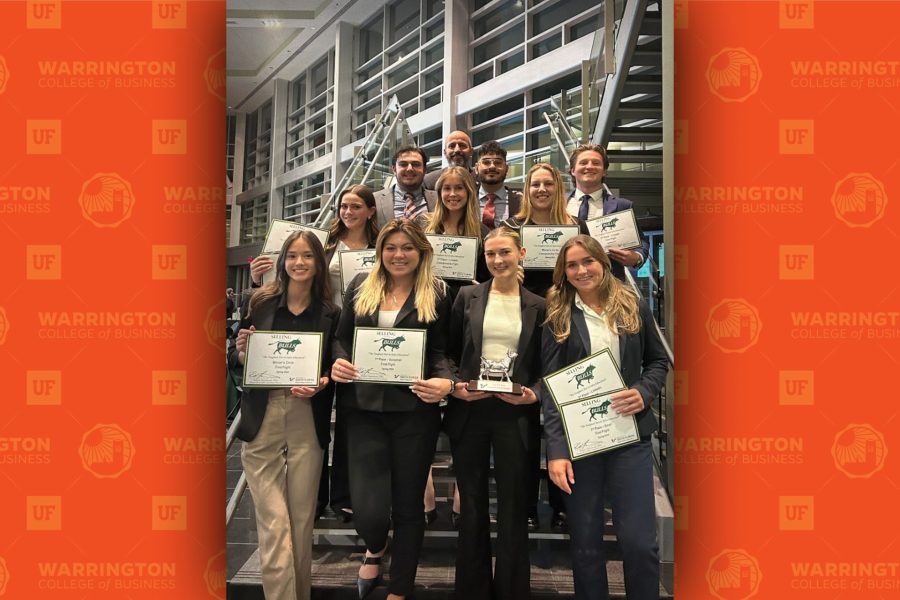 Students pose on a staircase with awards.