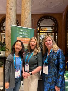 Three women in a conference hall.