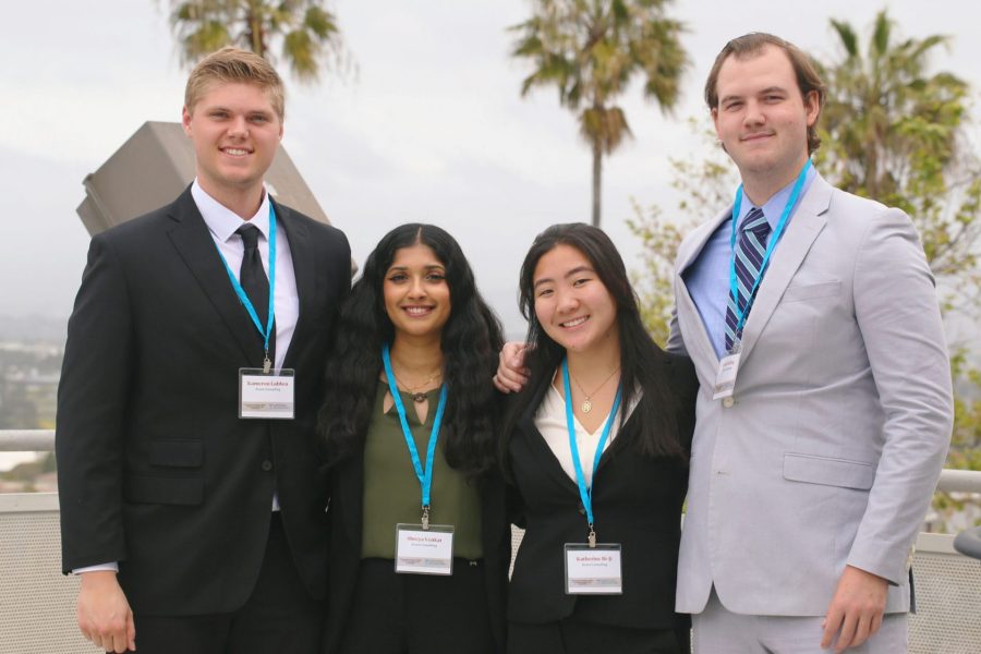 Students pose with palm trees in the background.