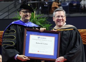 Saby Mitra and Rob Carter hold a framed certificate.