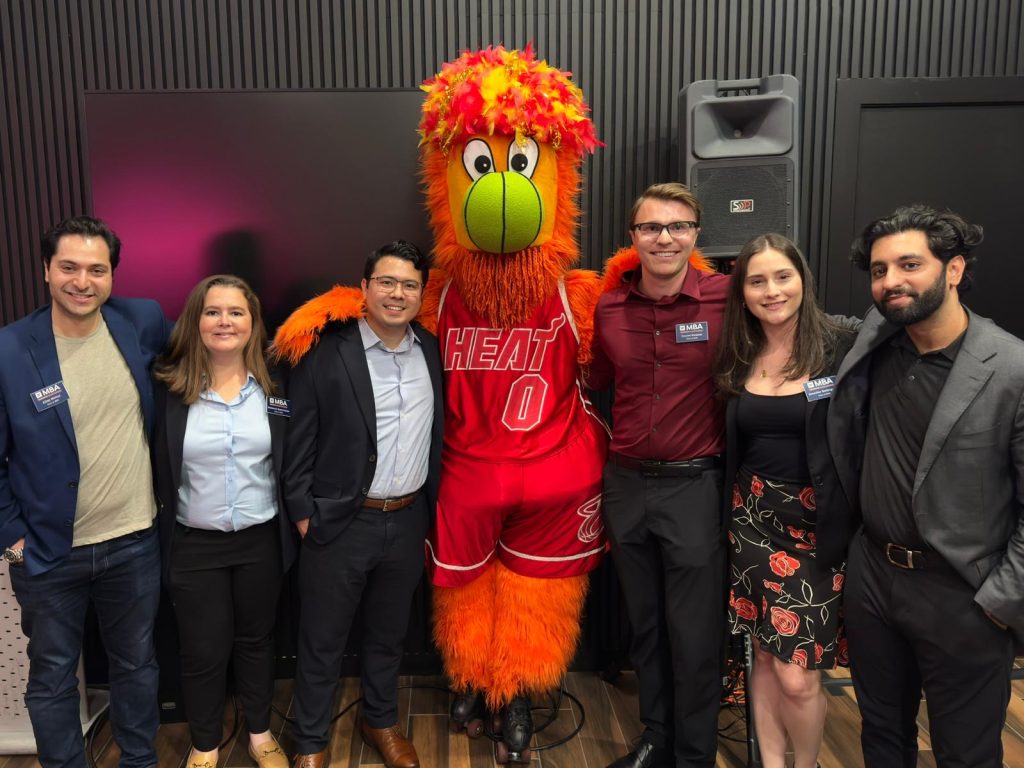 Six students posing for a photo with Burnie, the Miami Heat mascot.