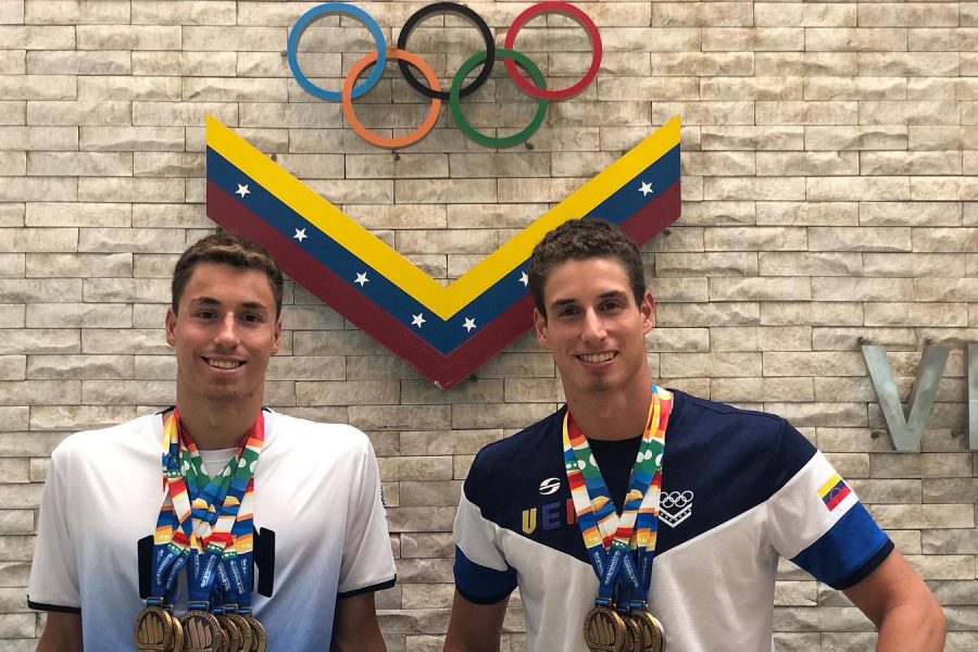 Alfonso Mestre and Alberto Mestre stand in front of the Olympic rings