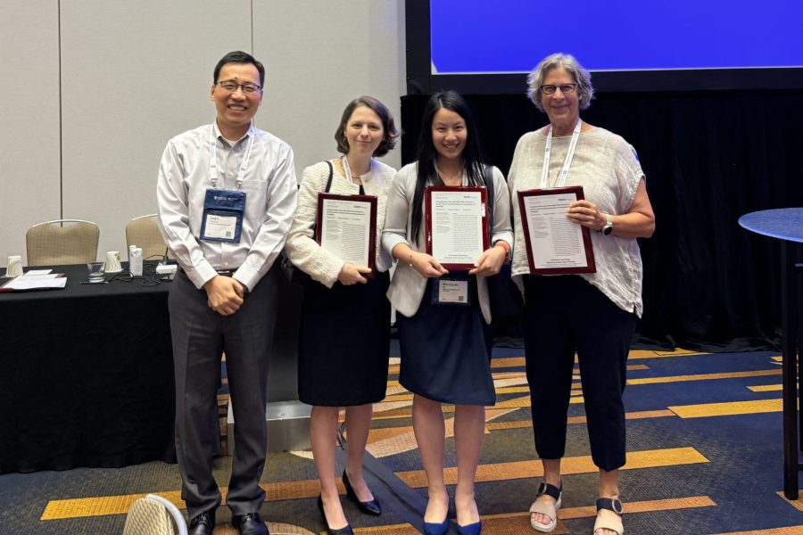 Four people, including Elisabeth Gilbert, Min-Hsuan Tu and Joyce Bono, post for a photo holding awards for their research paper.