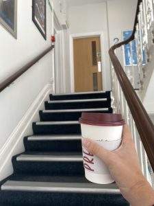 Walking up stairs with coffee in hand