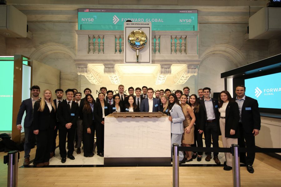 A large group of students stands at the opening bell of the New York Stock Exchange.