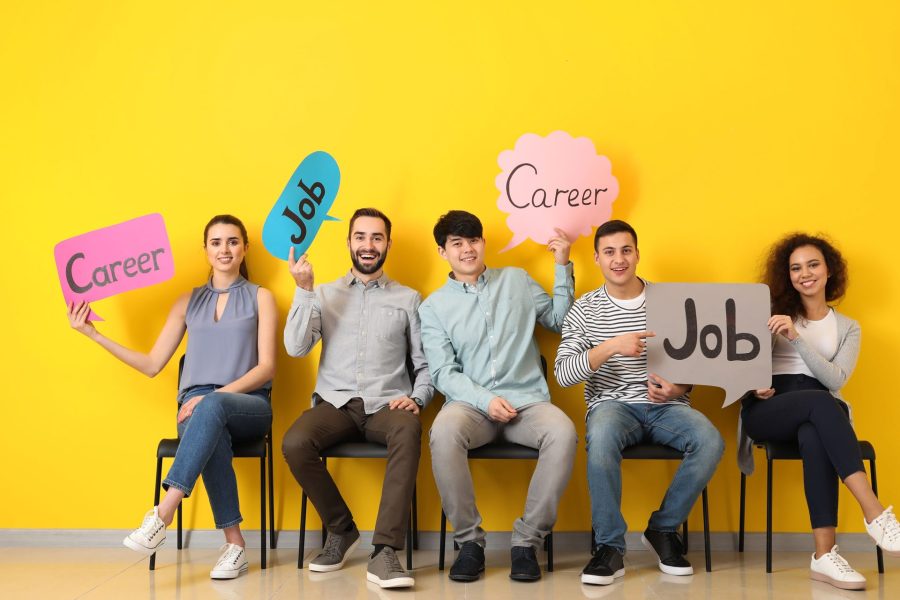 Young people holding speech bubbles with words JOB and CAREER indoors.