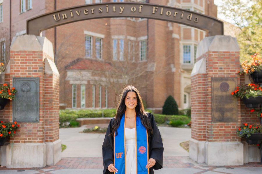 Nicole Acosta in graduate regalia under a University of Florida archway.
