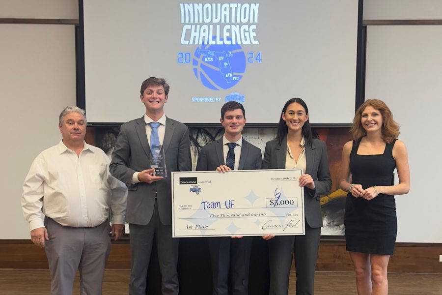 University of Florida students hold awarded first place $6,000 check under a projection reading Innovation Challenge.