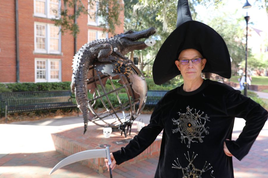 Robert Emerson dressed in a witch costume in front of the Gator Ubiquity Statue.