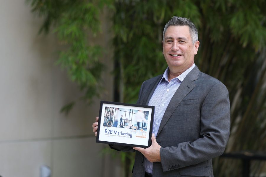 Mike Carrillo display cover of his textbook, B2B Marketing.