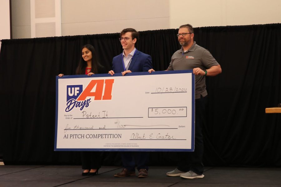 Winners Ashni Zaverchand and Alexander Simes hold their 5,000 dollar check with Jamie Kraft