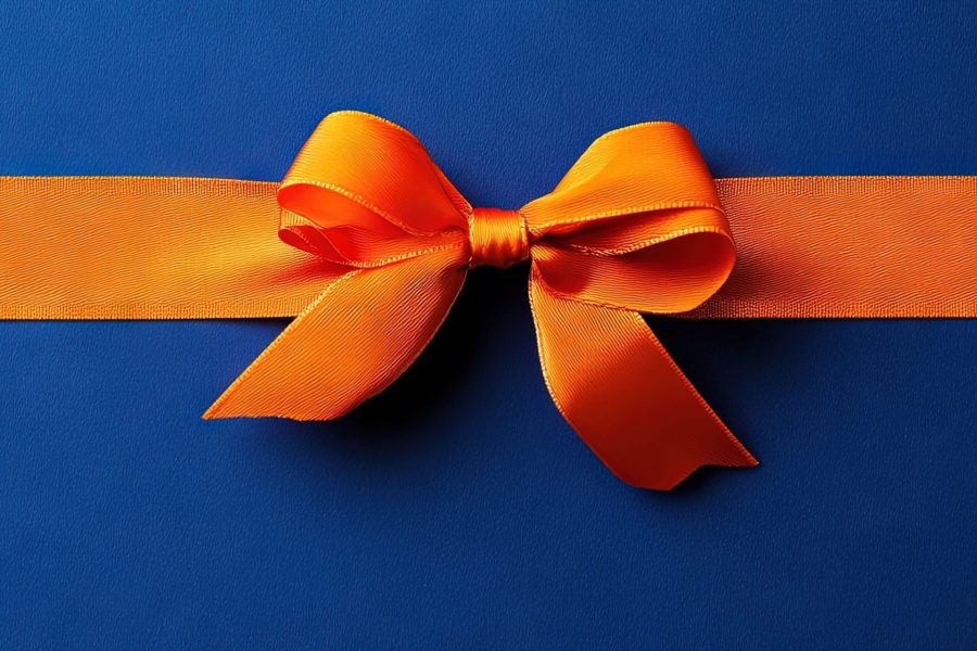 An orange ribbon and bow on royal blue background