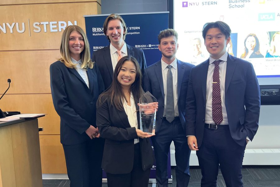 Five students display their first-place award at a case competition.