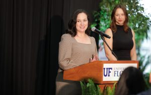 Mikaela Moore speaks at a podium during an awards ceremony for students.