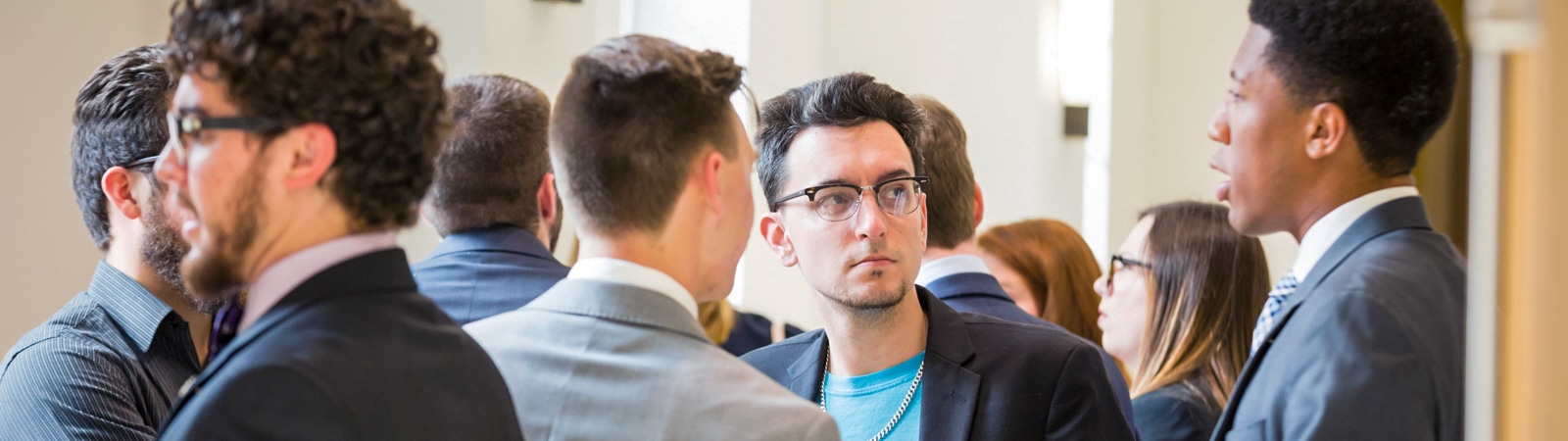 Students engaged in conversation during a GatorSLAM networking event at the Warrington College of Business.