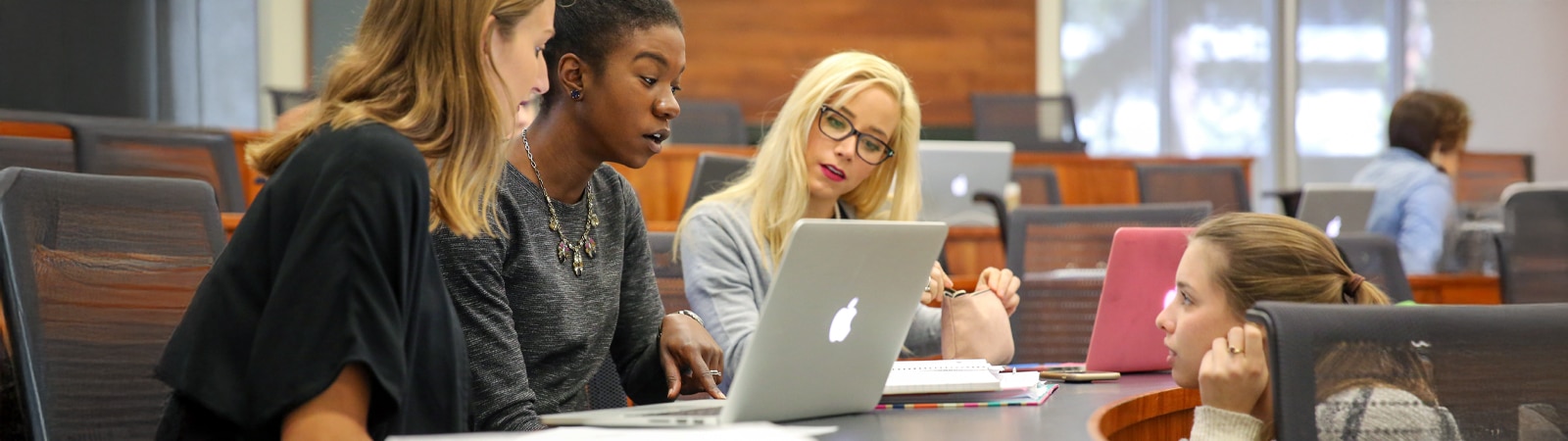 Graduate students at the Warrington College of Business review and discuss coursework in a Hough Hall classroom.