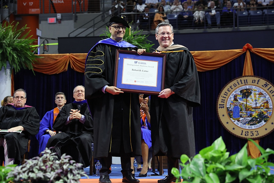 A University of Florida Warrington College of Business alum smiles while receiving the Distinguished Alumnus Award on stage