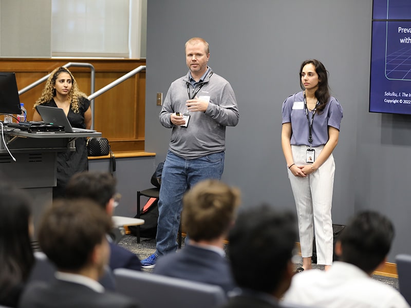 Deloitte employees presenting to business students.