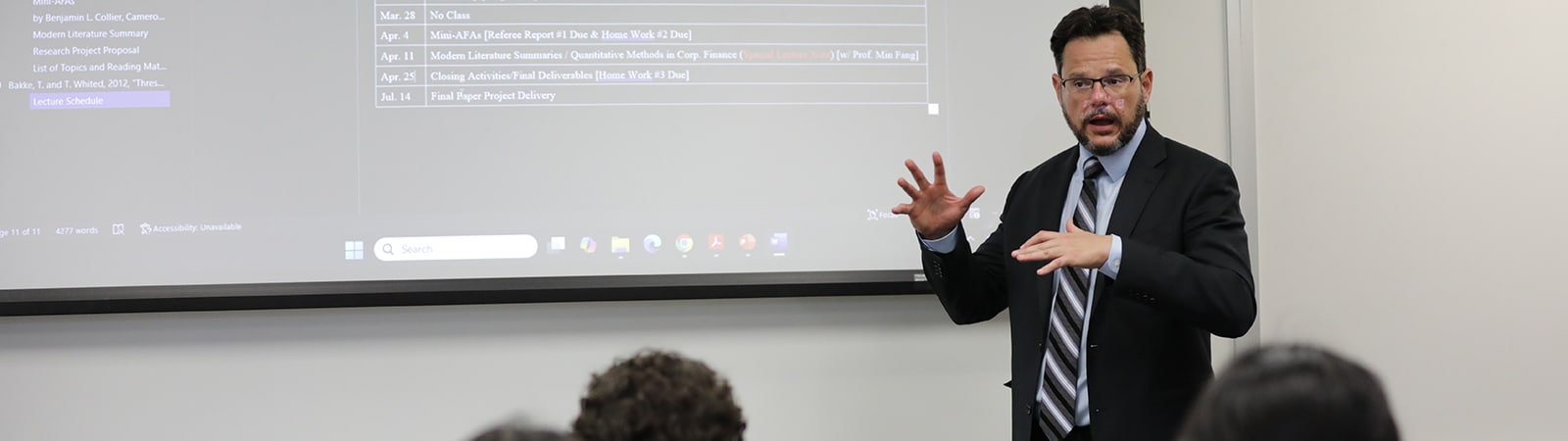 A University of Florida Warrington College of Business faculty member discusses a schedule with a class of students