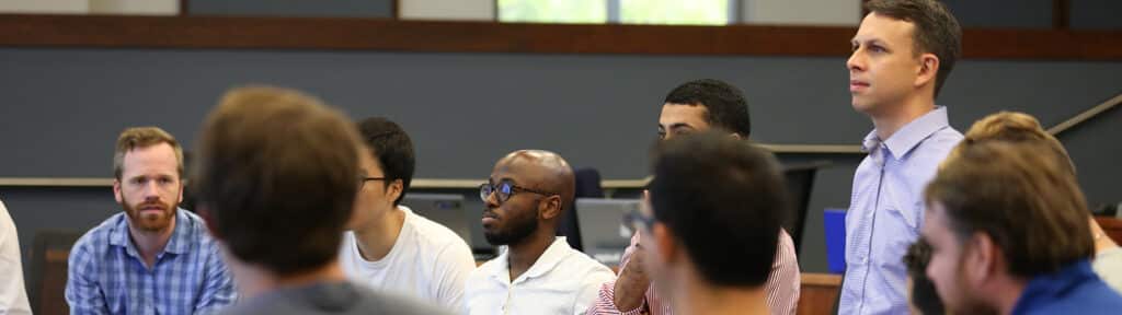 A group of graduate students from the University of Florida Warrington College of Business sit in a circle in a classroom