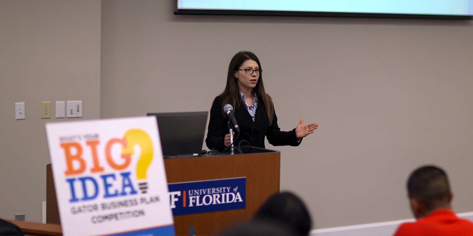 A student from UF Warrington's MS in Entrepreneurship program stands in front of an audience to present her business plan during the Big Idea Business Plan Competition