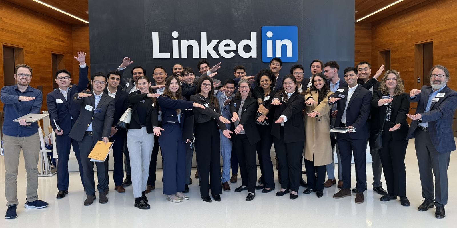A group of students from UF Warrington's MS in Entrepreneurship program make Gator arms while inside LinkedIn's headquarters during the Silicon Valley trip