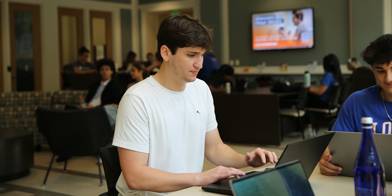A student from UF Warrington's MS in Management program types on a laptop during a career development activity