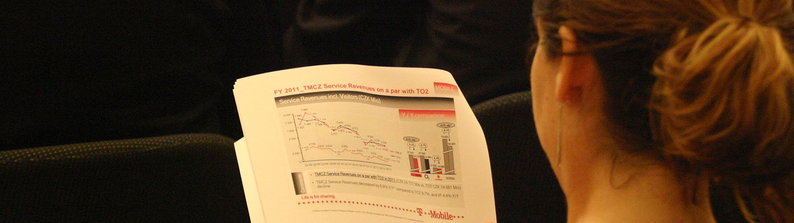 A student from the University of Florida Warrington College of Business' Online MS Marketing program reviews a printed packet with a graph