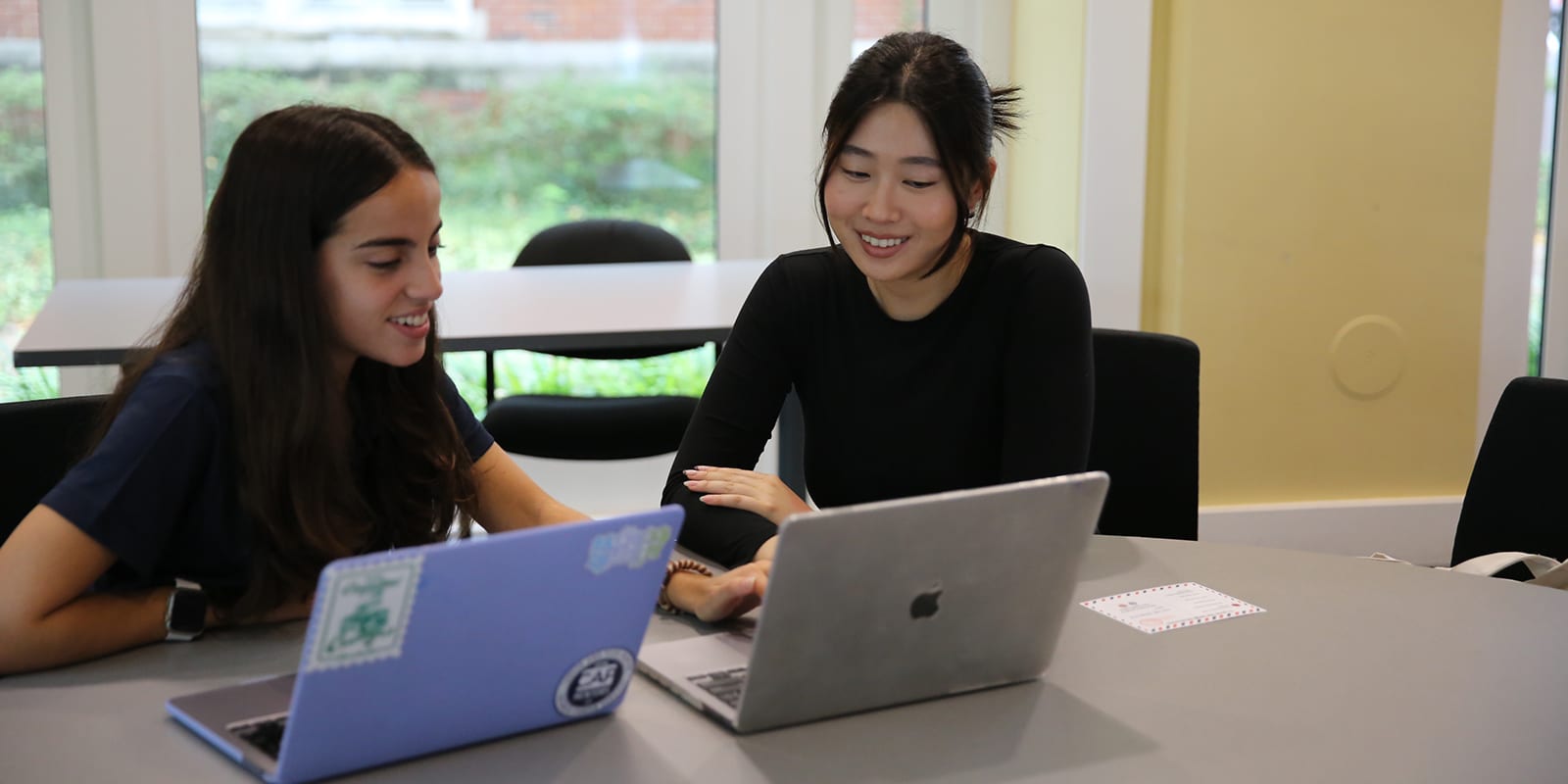 Using laptops, an MS Marketing student meet with one of UF Warrington's counselors for a career coaching session