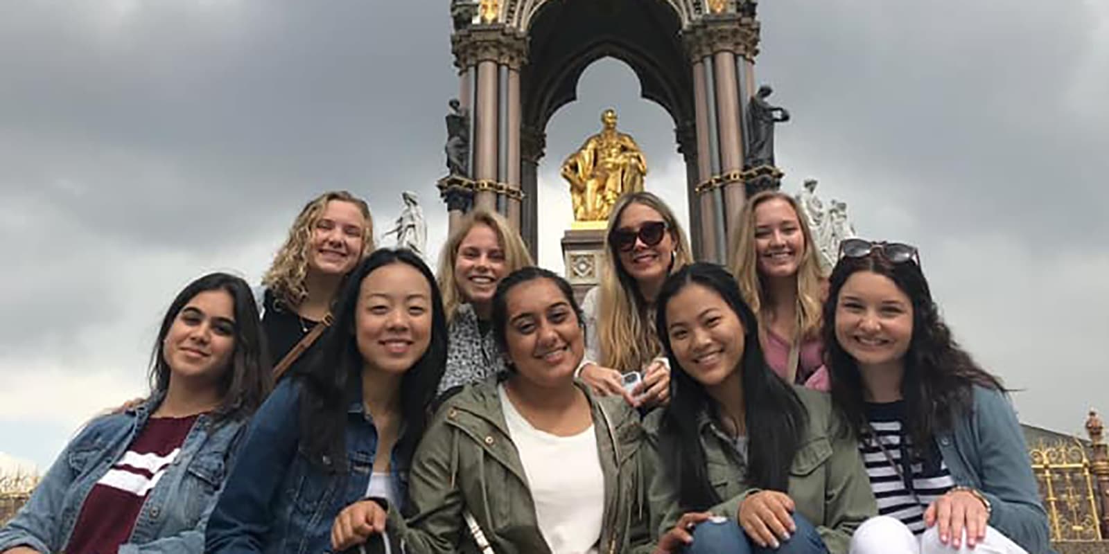 On a study abroad trip, a group of students from UF Warrington's MS Marketing program smile and pose in front of a gold-colored statue