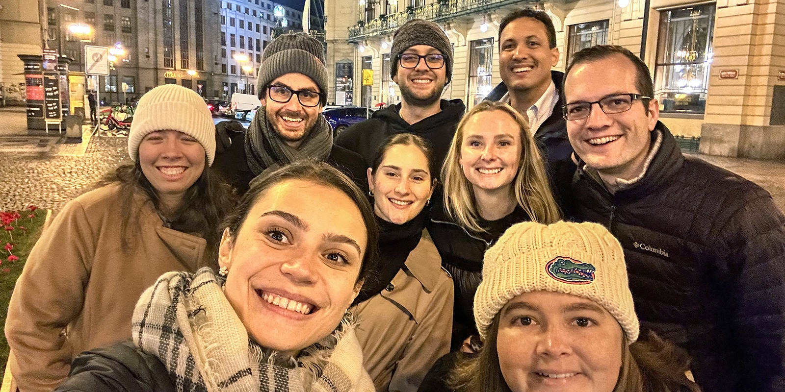 A group of students from the University of Florida Warrington College of Business' Master of International Business program stand in front of an illuminated building during a Global Immersion Experience