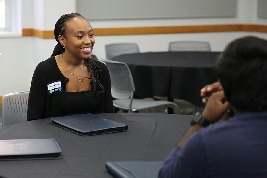University of Florida undergraduates enrolled in the Warrington College of Business' Real Estate Minor sit around a table with portfolios