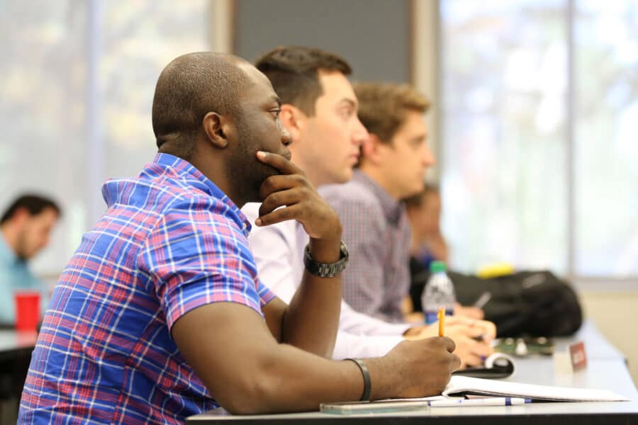 A row of students in class attentively listening
