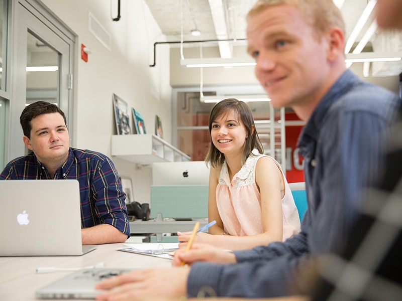 Happy students around a table. 