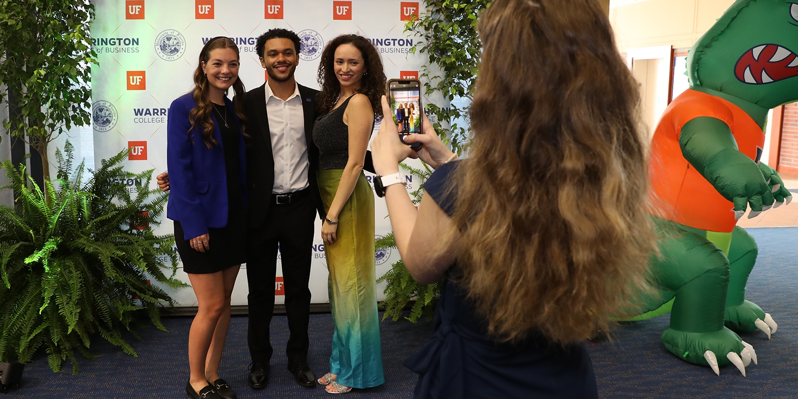 Students posing in front of a Warrington backdrop.
