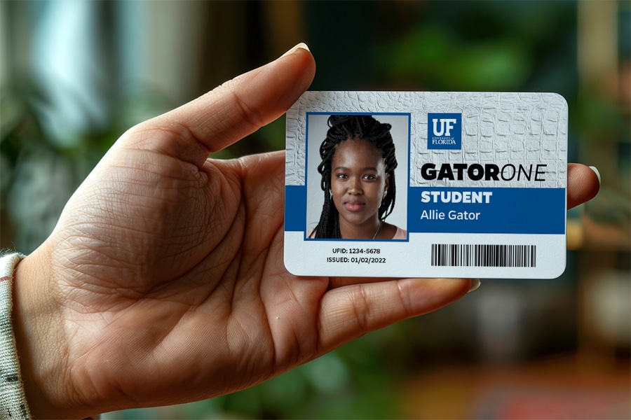 Hand holding a GATORONE identification card. 