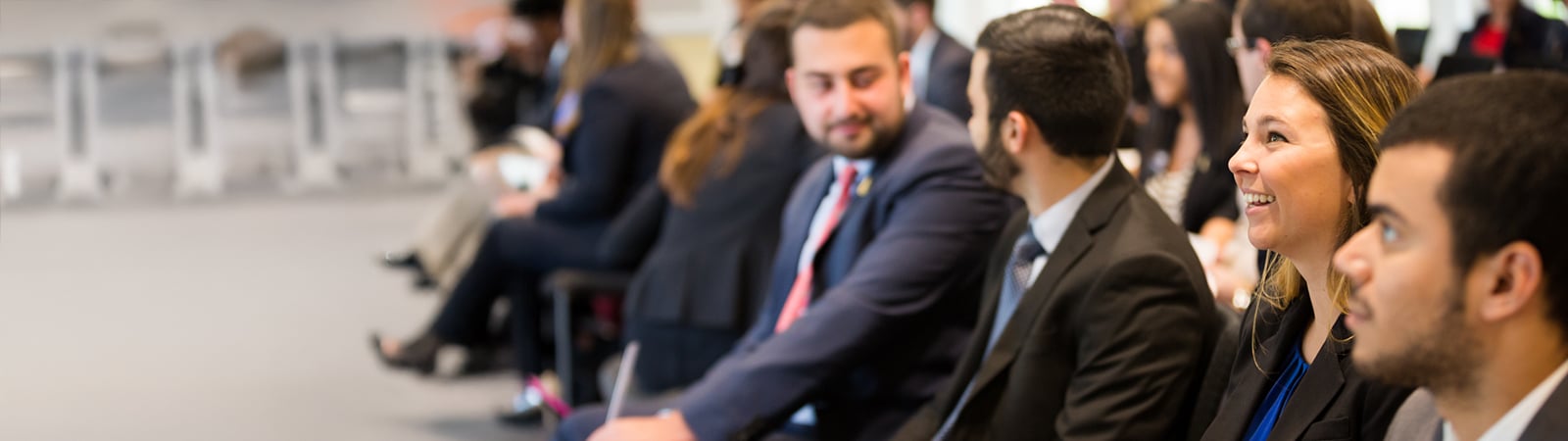 Group of smiling students attending a lecture.