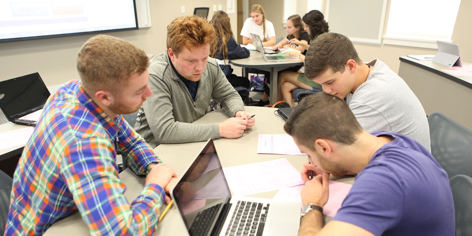 A group of students working together around a table. 