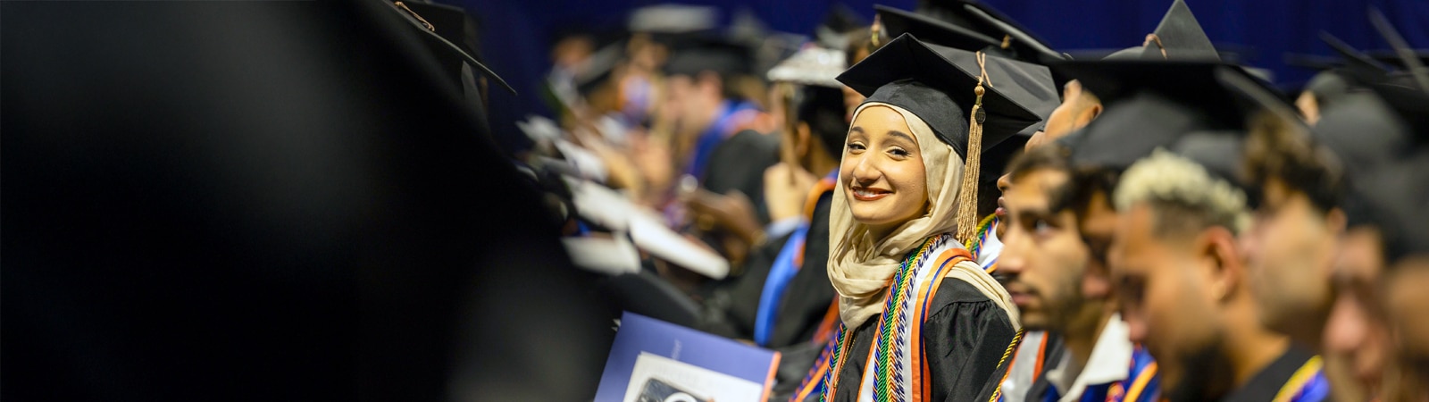 Happy students during commencement in cap and gown attire. 