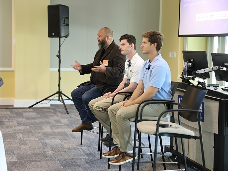 Professor Joel Davis speaking on a panel with students. 