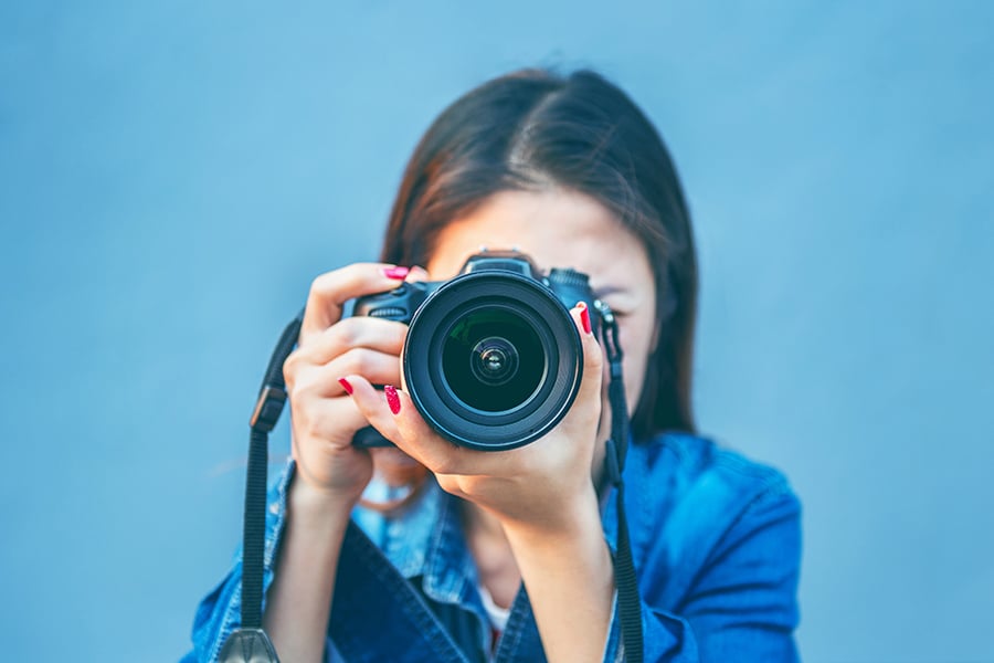 Photographer taking pictures with digital camera.