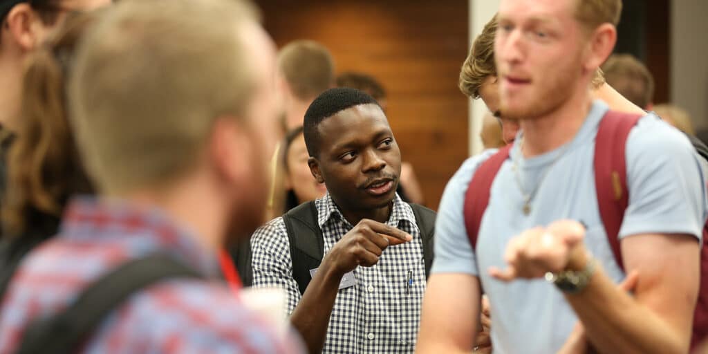 A group of UF Warrington undergraduates, including those from the Online BSBA program, socialize before a meeting in Gainesville