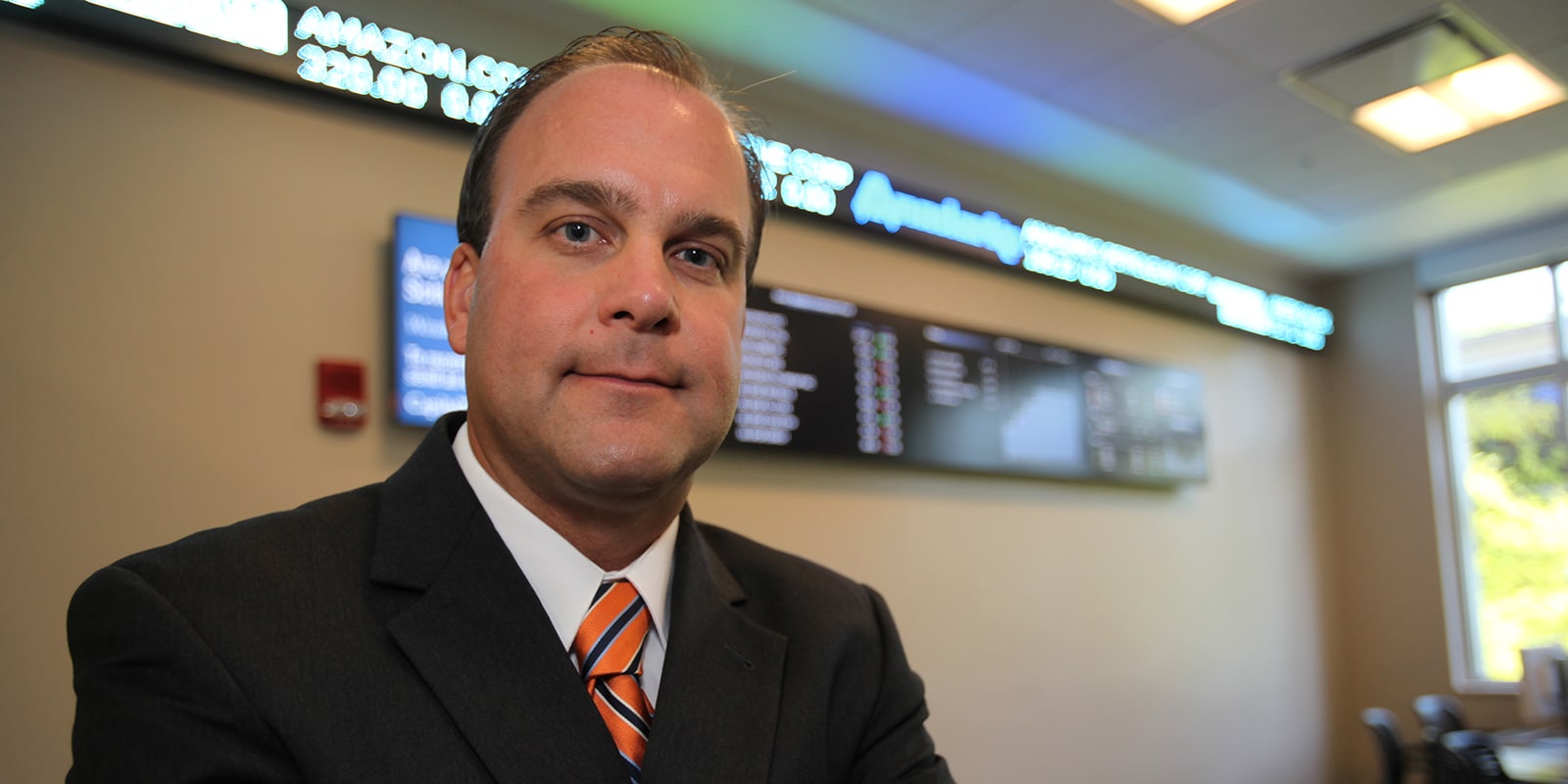 A student from UF Warrington's Online MS in Business Analytics program sits on a traderoom floor