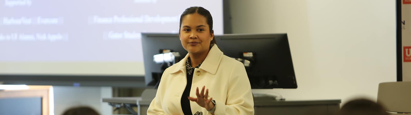 A student from the University of Florida Warrington College of Business' PhD in Finance and Real Estate program presents their research while standing in front of a screen